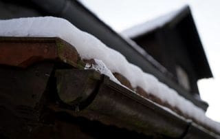 winterize your home to protect from damage from ice and snow on roof and in gutter on house