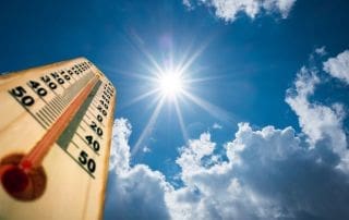 thermostat shows record high temperatures in direct sunlight, demonstrating need for smart solar attic fan